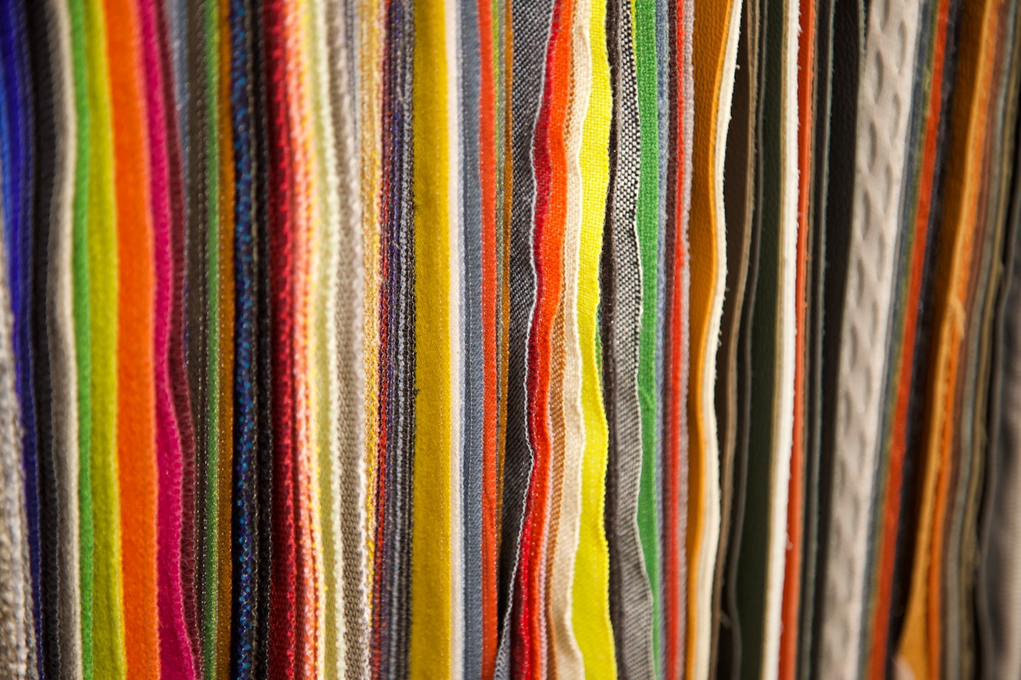 Colorful fabric swatches hanging vertically in a shop.