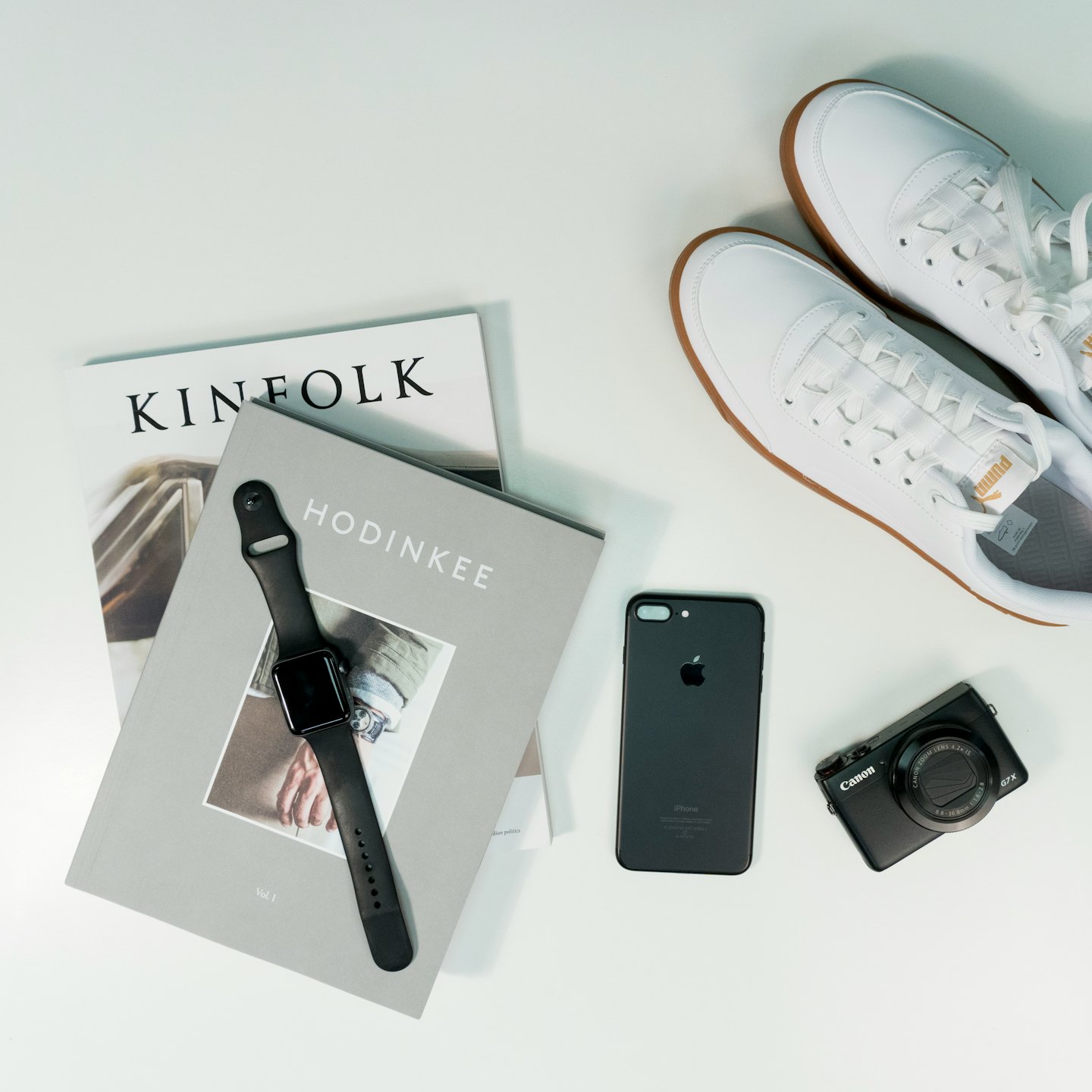 Modern accessories and lifestyle items arranged on a white surface.